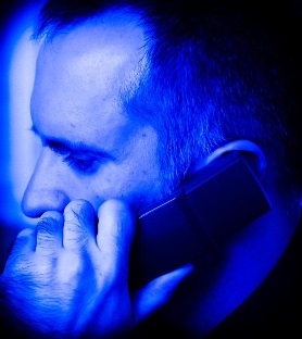 mężczyzna trzymający przy uchu słuchawkę od telefonu