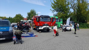 uczestnicy pikniku oglądający pojazdy przygotowane przez służby i fundację