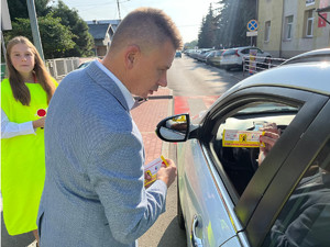 dyrektor małopolskiego ośrodka ruchu drogowego w tarnowie wręcza ulotkę zwalniam przed szkołą kierowcy