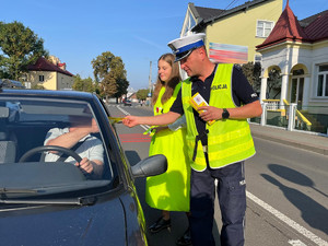 policjant wręczający ulotkę zwalniam przed szkołą kierowcy