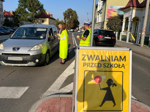 uczestnicy akcji zwalniam przed szkołą wręczający ulotki kierowcom