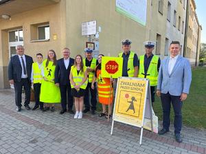 zdjęcie grupowe policjantów z burmistrzem Brzeska, dyrektorem szkoły nr 1 w Brzesku, dyrektorem małopolskiego ośrodka ruchu drogowego w tarnowie oraz uczniami szkoły podczas akcji