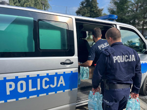 policjanci przewożący dary dla powodzian