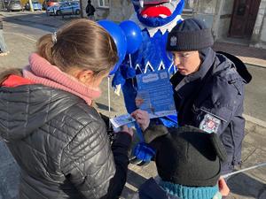 policjantka opowiadająca dzieciom o zasadach bezpieczny zabaw zimowych