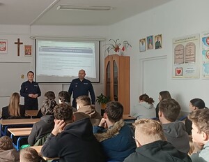 policjanci przemawiający do uczniów klas maturalnych