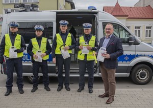 Policjanci Wydziału Ruchu Drogowego wraz z burmistrzem Brzeska na tle radiowozu