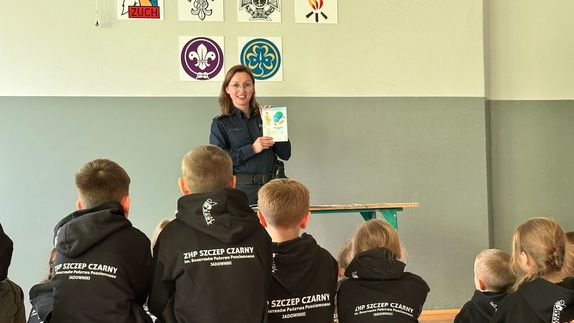 policjantka pokazująca harcerzom ulotkę