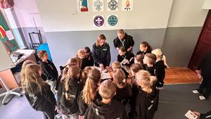 policjantka pokazująca harcerzom zabezpieczanie śladów