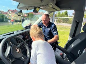 policjant pokazujący chłopcu radiowóz
