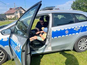 policjant pokazujący dziecku radiowóz