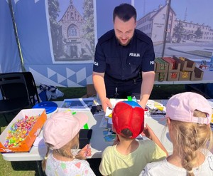 policjant wręczający dzieciom odblaski