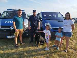 zdjęcie uczestników pikniku z policjantem trzymającym psa