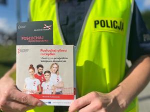 ulotka posłuchaj głosu rozsądku trzymana przez policjantkę