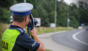 policjant trzymający w ręce radarowy miernik prędkości