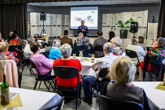 policjantka przemawiająca do grupy seniorów