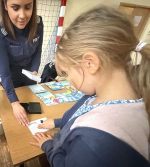 policjantka wykonująca dziewczynce odcisk paluszka