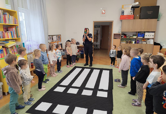 policjantka pokazująca dzieciom sygnalizator świetlny