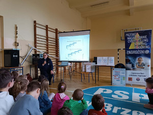 policjantka z mikrofonem prowadzi prelekcję dla uczniów