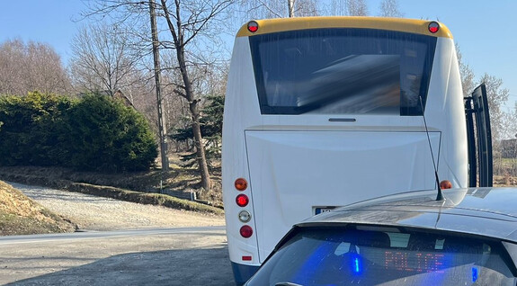 tył kontrolowanego bus, fragment radiowozu z widocznym na tylnej szybie napisem police