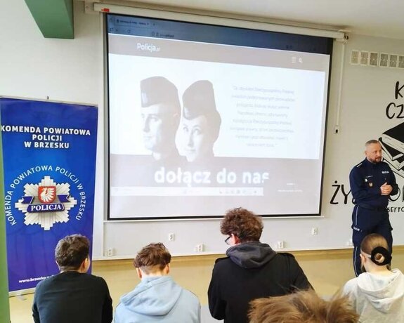 zastępca komendanta przemawiający do grupy młodzieży