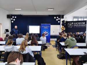 Zastępca komendanta przemawiający do grupy maturzystów siedzących przy ławkach