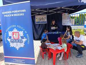 dzielnicowa pokazująca materiały profilaktyczne uczestnikom pikniku