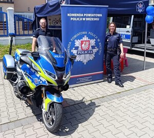 policjanci pozujący do zdjęcia przy policyjnym motocyklu