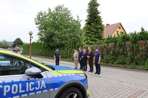 nowe radiowozy, w tle stoją komendant powiatowy policji w brzesku z włodarzami gmin
