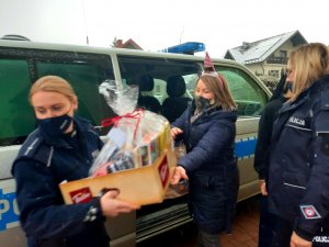 Policjantki wynoszą prezenty przeznaczone dla wychowanków DPS