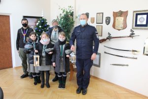 Komendant Powiatowy Policji w Brzesku insp. Bogusław Chmielarz przyjmuję od harcerzy Hufca ZHP Brzesko im. Mikołaja Kopernika Światełko Betlejemskie