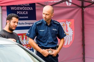 policjant Wydziału Ruchu Drogowego Komendy Wojewódzkiej Policji w Krakowie rozmawiający z mężczyzną