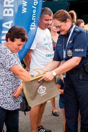 policjantka rozdająca cukierki kobiecie