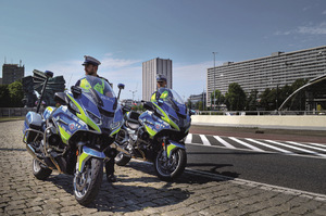 dwóch umundurowanych policjantów stoi obok motocykli służbowych