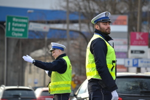 Policjanci ruchu drogowego ręcznie kierują ruchem na skrzyżowaniu