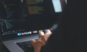 fragment ręki piszącej na klawiaturze laptopa