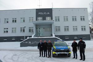 komendant powiatowy policji w Brzesku wraz z przedstawicielami samorządów stojący przy przekazywanym samochodzie — kopia