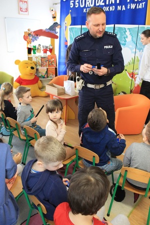 policjant rozdający odblaski dzieciom