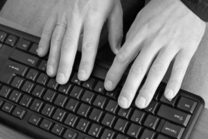 dłonie położone na klawiaturze komputerowej
