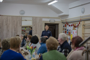 grupa seniorów przysłuchująca się wystąpieniu policjantki