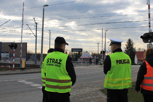 policjant, funkcjonariusze straży ochrony kolei, pracownik PKP w pobliżu przejazdu kolejowego