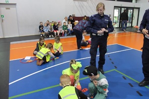 policjantka przyglądająca się rozwiązywaniu przez przedszkolaki zadania konkursowego