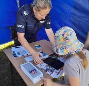 policjantka wykonująca dziewczynce odcisk linii papilarnych