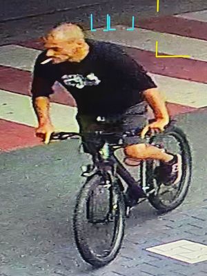 mężczyzna w czarnej bluzie jadący na rowerze