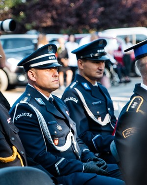 komendant brzeskiej policji wraz z kierownikiem rewiru dzielnicowych siedzą na krzesłach podczas uroczystych obchodów