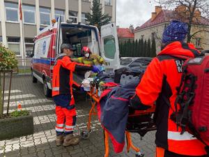 transport do karetki pogotowia poszkodowanego przez ratowników medycznych i strażaka