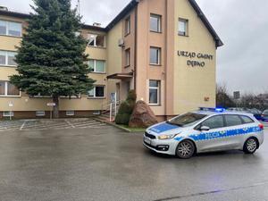 radiowóz policyjny na sygnałach jadący przed urząd gminy w Dębnie