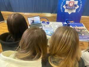 grupa uczennic oglądająca na laptopie wyświetlony test sprawnościowy wymagany w procesie rekrutacji do służby w policji