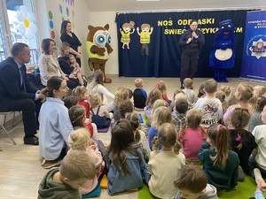 policjantka przemawiająca do grupy przedszkolaków